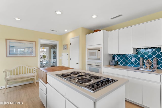 kitchen featuring white cabinetry, white appliances, and sink