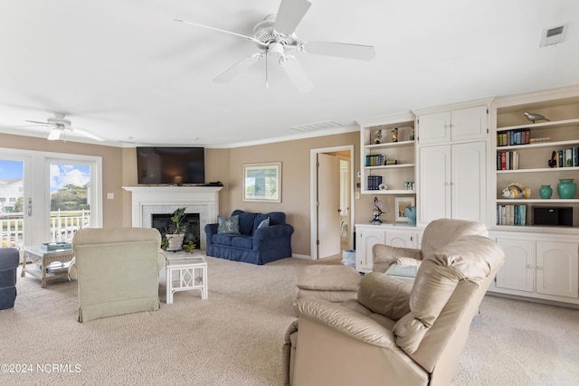 living room featuring light colored carpet, a brick fireplace, ceiling fan, and ornamental molding