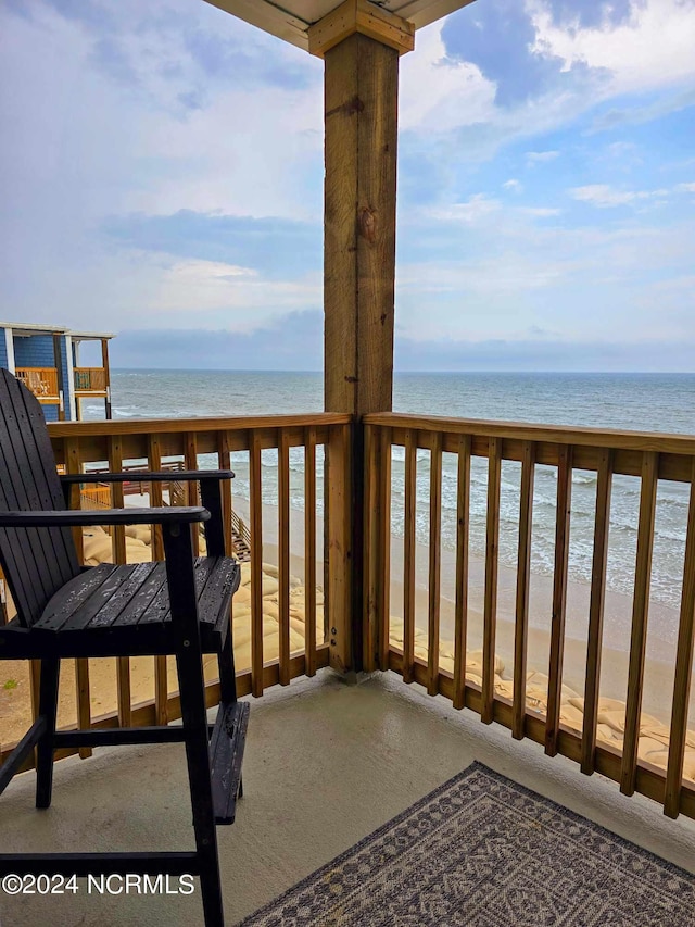 balcony featuring a beach view and a water view