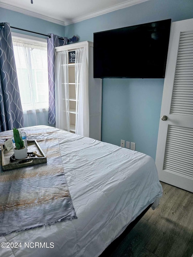 bedroom featuring wood-type flooring and ornamental molding