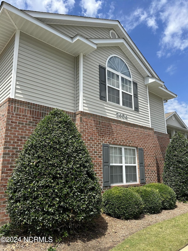 view of side of home featuring brick siding