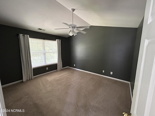 carpeted spare room featuring lofted ceiling, ceiling fan, visible vents, and baseboards