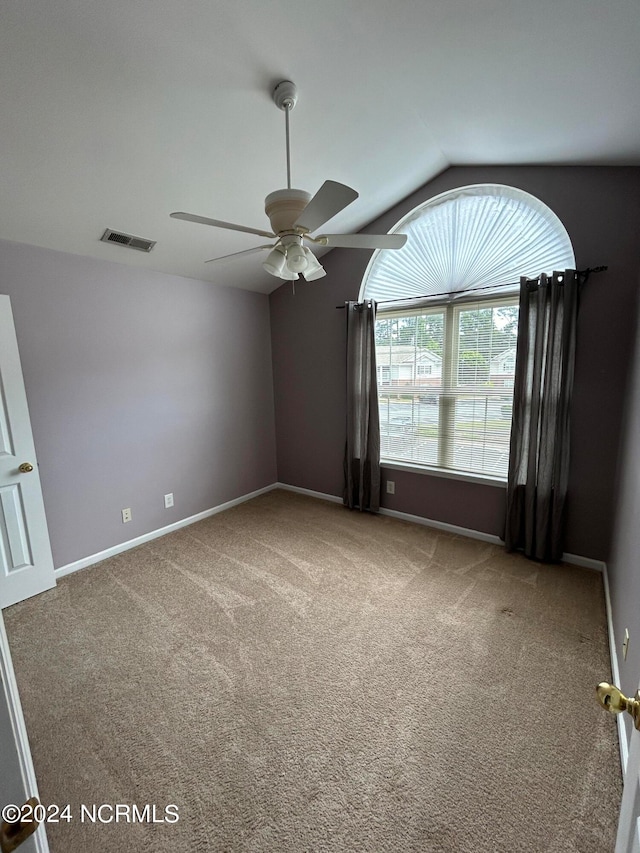 carpeted spare room with lofted ceiling and ceiling fan