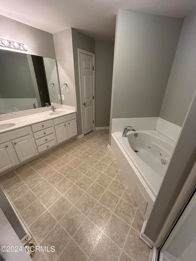 bathroom with tiled bath, double vanity, and tile flooring