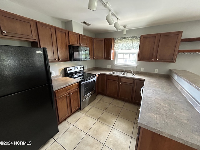 kitchen featuring light tile patterned floors, visible vents, light countertops, black appliances, and a sink