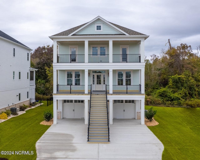 view of front of home featuring cooling unit, a front lawn, a garage, and a balcony