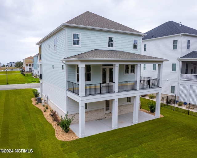 rear view of house featuring a balcony, a yard, cooling unit, and a patio area