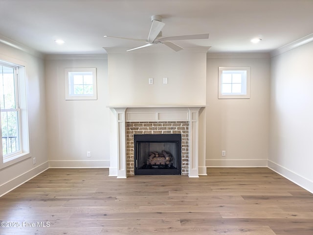 unfurnished living room with a healthy amount of sunlight, ornamental molding, and light wood-type flooring