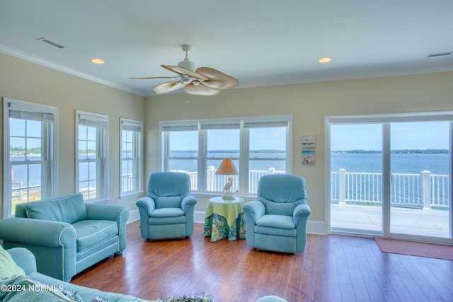 living room with ceiling fan, crown molding, a water view, and wood-type flooring