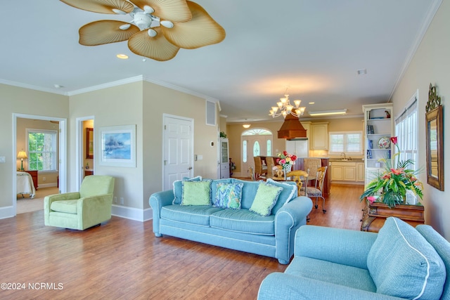 living room with crown molding, plenty of natural light, and light hardwood / wood-style floors