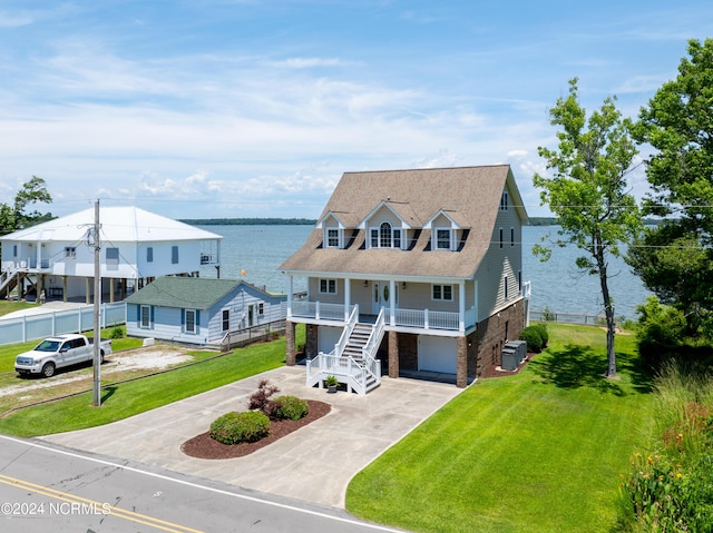 view of front of home with a front lawn, a water view, central AC, covered porch, and a garage