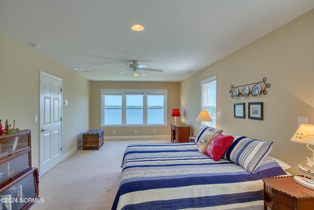 carpeted bedroom with ceiling fan and a water view