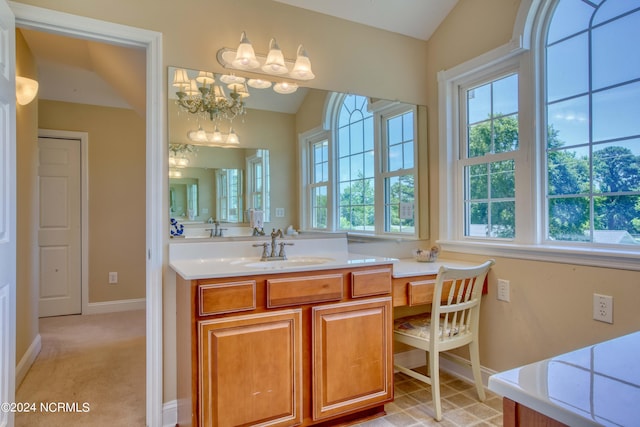 bathroom with an inviting chandelier, vaulted ceiling, and plenty of natural light