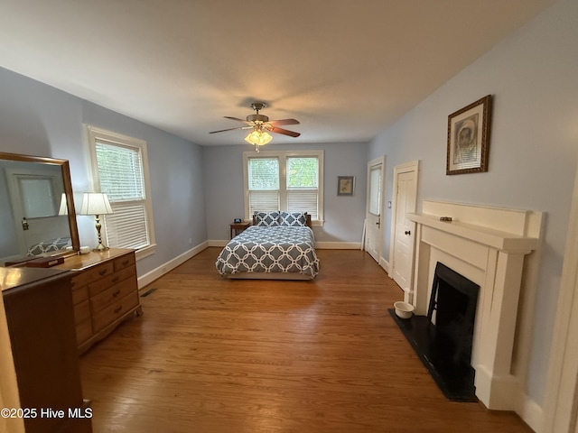 104 Rockingham St, Carthage, NC 28327 - bedroom featuring wood finished floors, a fireplace with raised hearth, and a ceiling fan