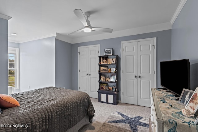 bedroom with light carpet, crown molding, ceiling fan, and two closets