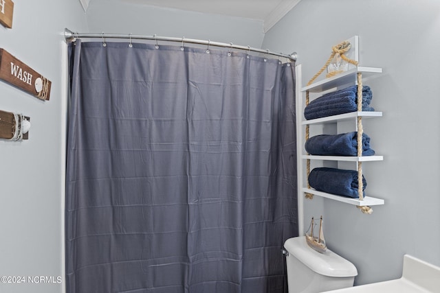 bathroom with walk in shower, crown molding, and toilet