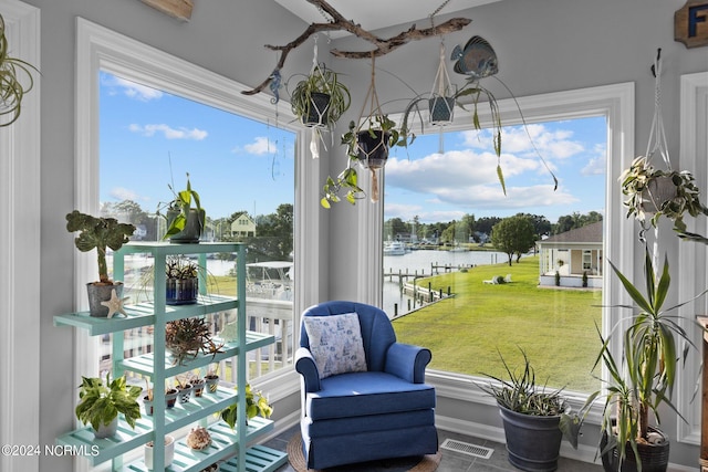 sunroom / solarium with a water view and a healthy amount of sunlight