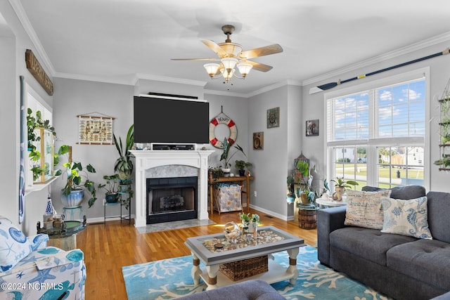 living room featuring hardwood / wood-style floors, ceiling fan, and crown molding