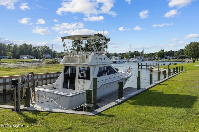 view of dock with a lawn and a water view