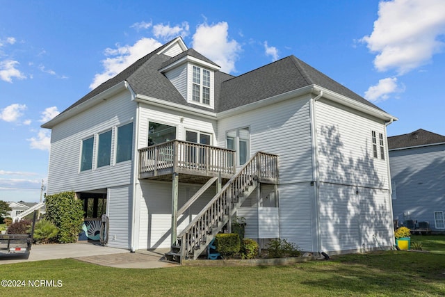 rear view of house featuring a deck and a lawn