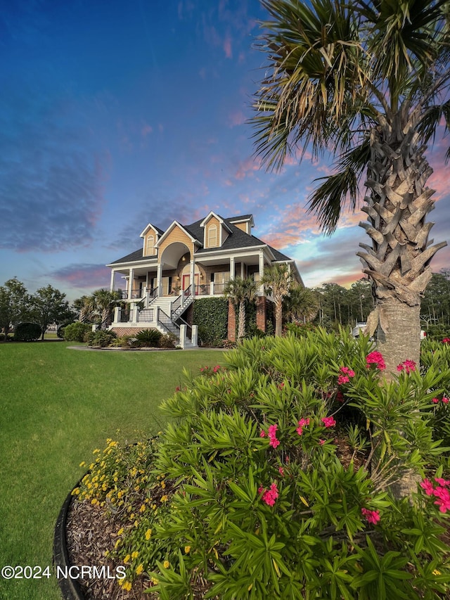 view of front of house featuring a lawn and covered porch