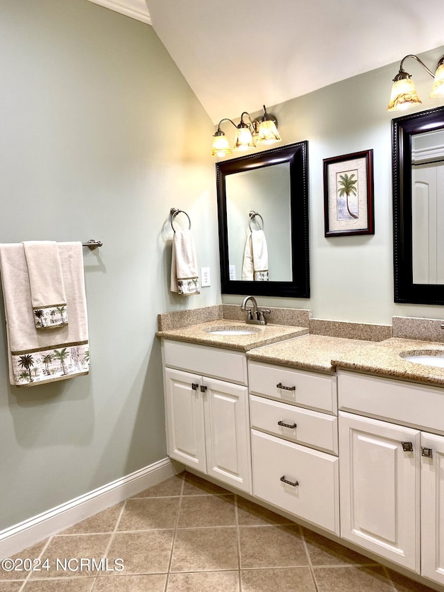 bathroom with tile patterned floors, lofted ceiling, and dual bowl vanity