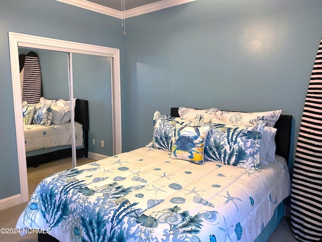 carpeted bedroom with crown molding and a closet