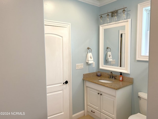 bathroom with vanity, crown molding, and toilet