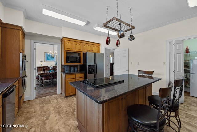 kitchen featuring light tile flooring, dark stone countertops, a center island, a breakfast bar area, and appliances with stainless steel finishes