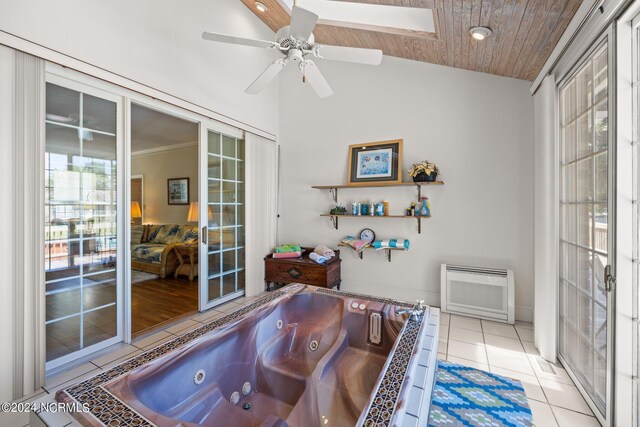 bathroom featuring tile flooring, radiator, wooden ceiling, vaulted ceiling with skylight, and ceiling fan