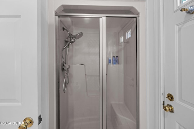 bathroom featuring a shower with door