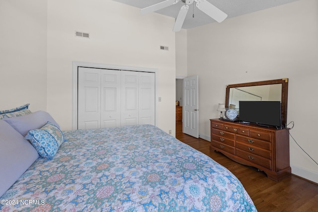 bedroom featuring a high ceiling, a closet, ceiling fan, and dark hardwood / wood-style flooring