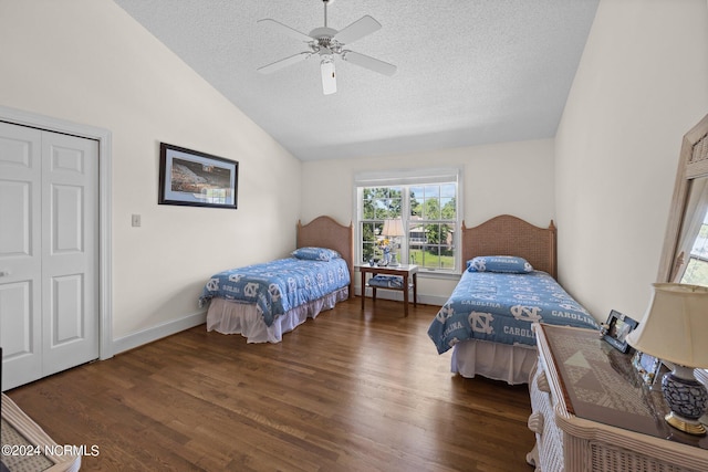 bedroom featuring a closet, ceiling fan, dark wood-type flooring, a textured ceiling, and lofted ceiling