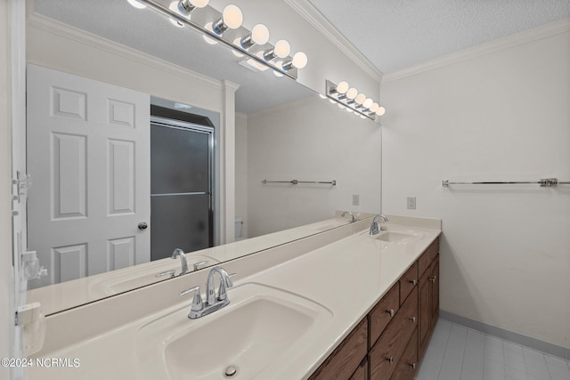 bathroom featuring ornamental molding, a shower with shower door, a textured ceiling, and vanity