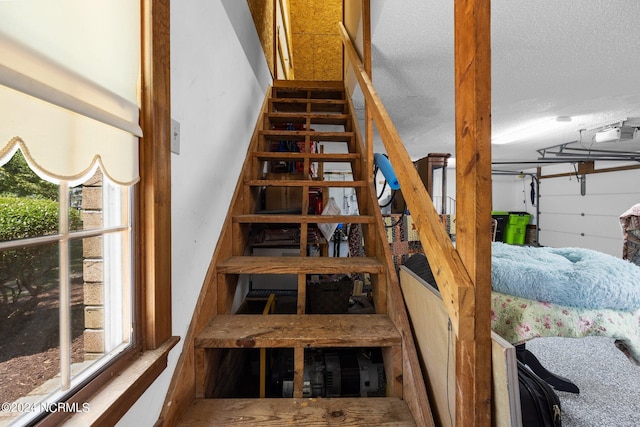 staircase with a textured ceiling