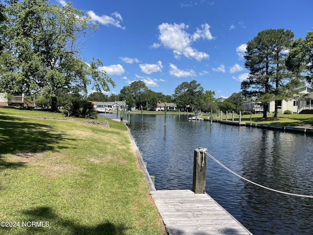 dock area with a water view and a lawn