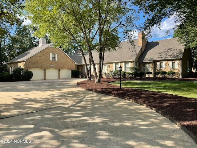 new england style home featuring a garage and a front yard