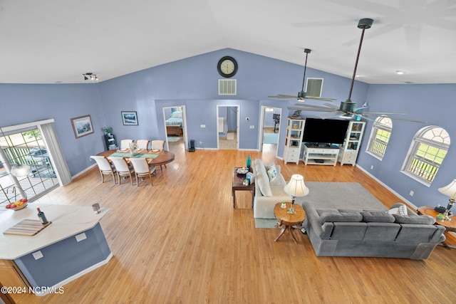 living room featuring a ceiling fan, light wood-type flooring, visible vents, and baseboards