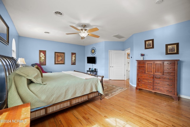 bedroom featuring light wood-style floors, visible vents, ceiling fan, and baseboards