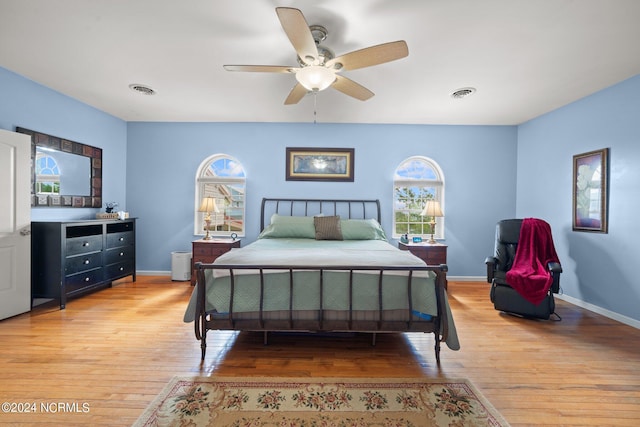 bedroom with visible vents, light wood-style flooring, and baseboards