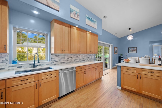 kitchen with dishwasher, light countertops, a sink, and lofted ceiling