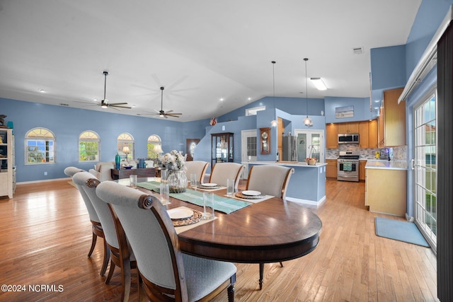 dining space featuring lofted ceiling, light wood finished floors, and baseboards