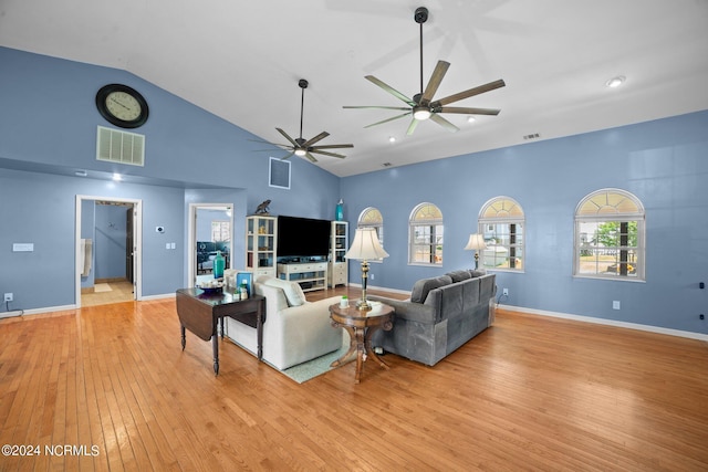 living area with light wood-type flooring, high vaulted ceiling, baseboards, and visible vents