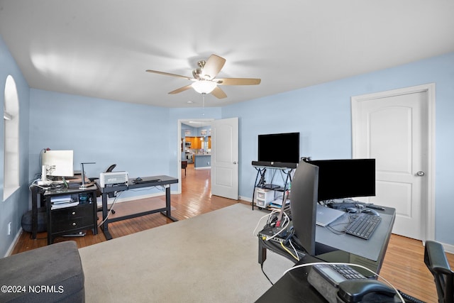 home office featuring ceiling fan, baseboards, and wood finished floors