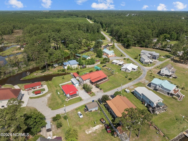 aerial view with a water view and a wooded view