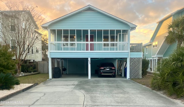 raised beach house with a sunroom and a carport