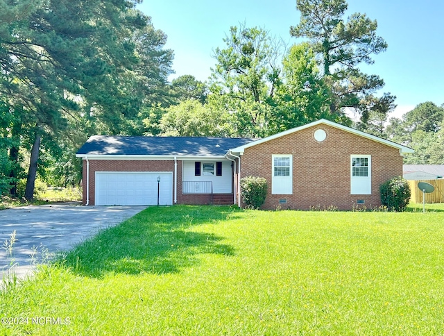 single story home featuring a porch, a front yard, and a garage