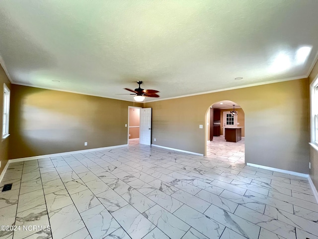 empty room featuring ceiling fan and ornamental molding