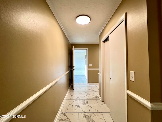 corridor with ornamental molding and a textured ceiling