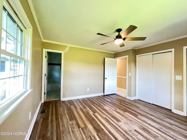 unfurnished bedroom featuring ornamental molding, ceiling fan, wood-type flooring, connected bathroom, and a closet